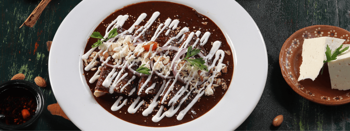 Enmoladas poblanas con crema con queso fresco al lado